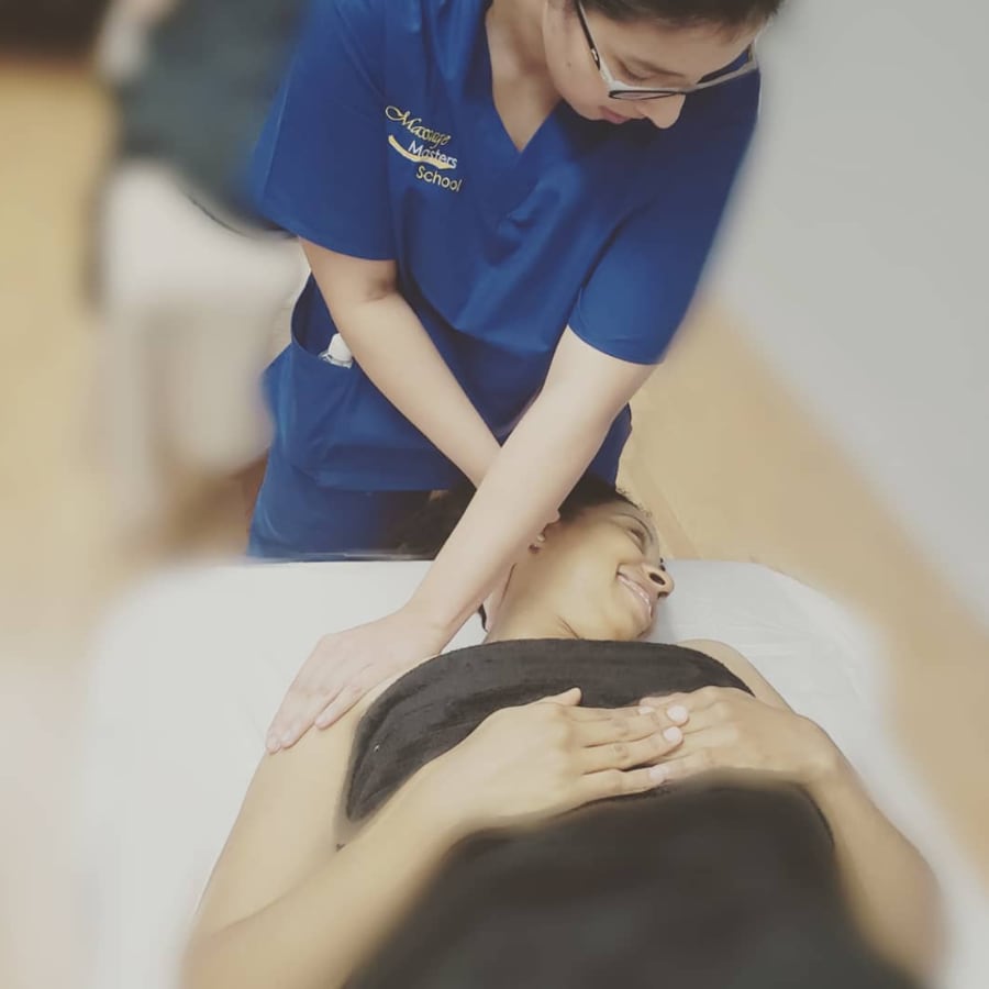 A Massage Masters School student performing a massage on a client